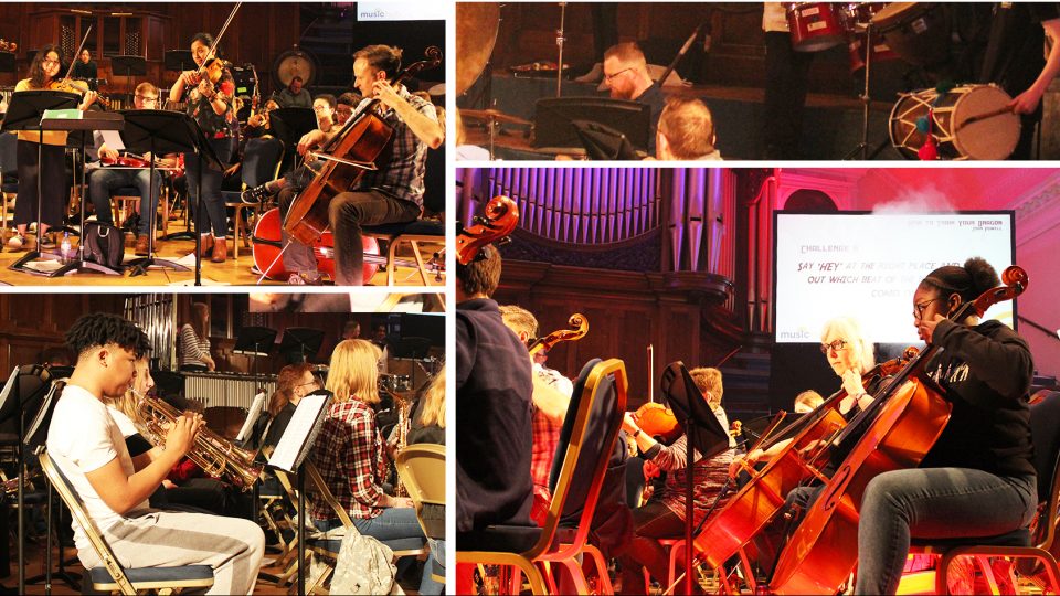 A group of people with mixed identities and age are playing a range of brass, string and percussion instruments