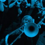 A group of people with mixed identities playing brass instruments.