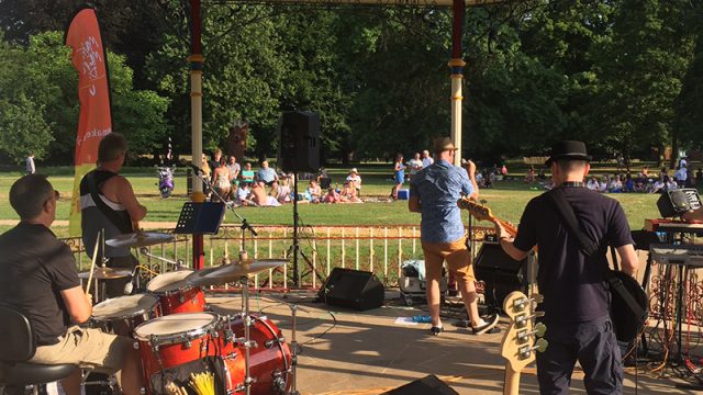 Musicians playing various instruments on a bandstand
