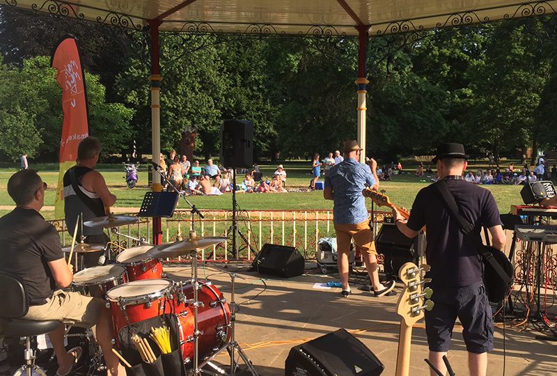 Musicians playing various instruments on a bandstand